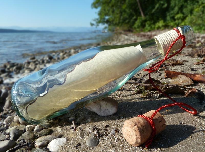 Flaschenpost am Strand liegend