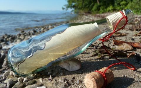 Flaschenpost am Strand liegend